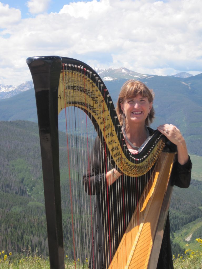 Barbara playing harp wedding music in Vail, Colorado on the top of a mountain.